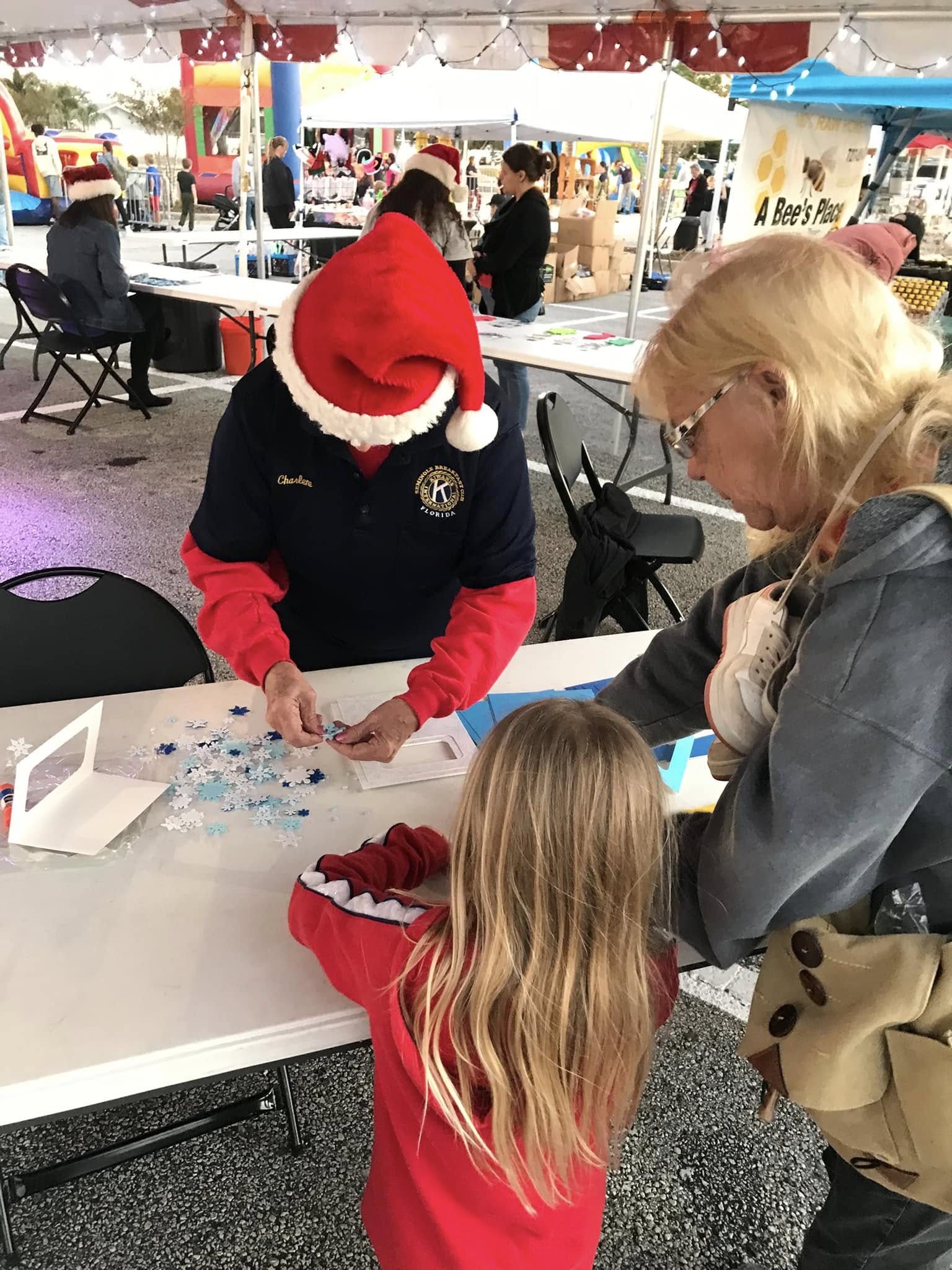 Charlene helping children make a holiday crafts at Seminole Winterfest!